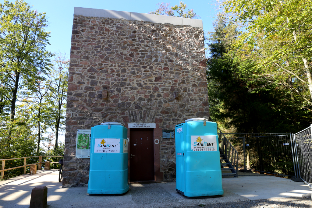 Stumpf des alten Ireneturms auf der Tromm, im Vordergrund zwei türkisfarbene Toilettenhäuschen