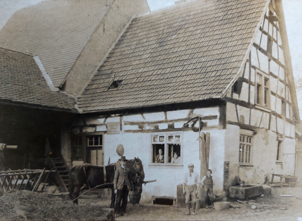 Altes schwarz-weiss Foto von der Landwirtschaft die zur Rippersmühle in Rimbach gehörte, Bauernhaus mit Familie in und beim Haus, davor ein Pferd und der Müller.