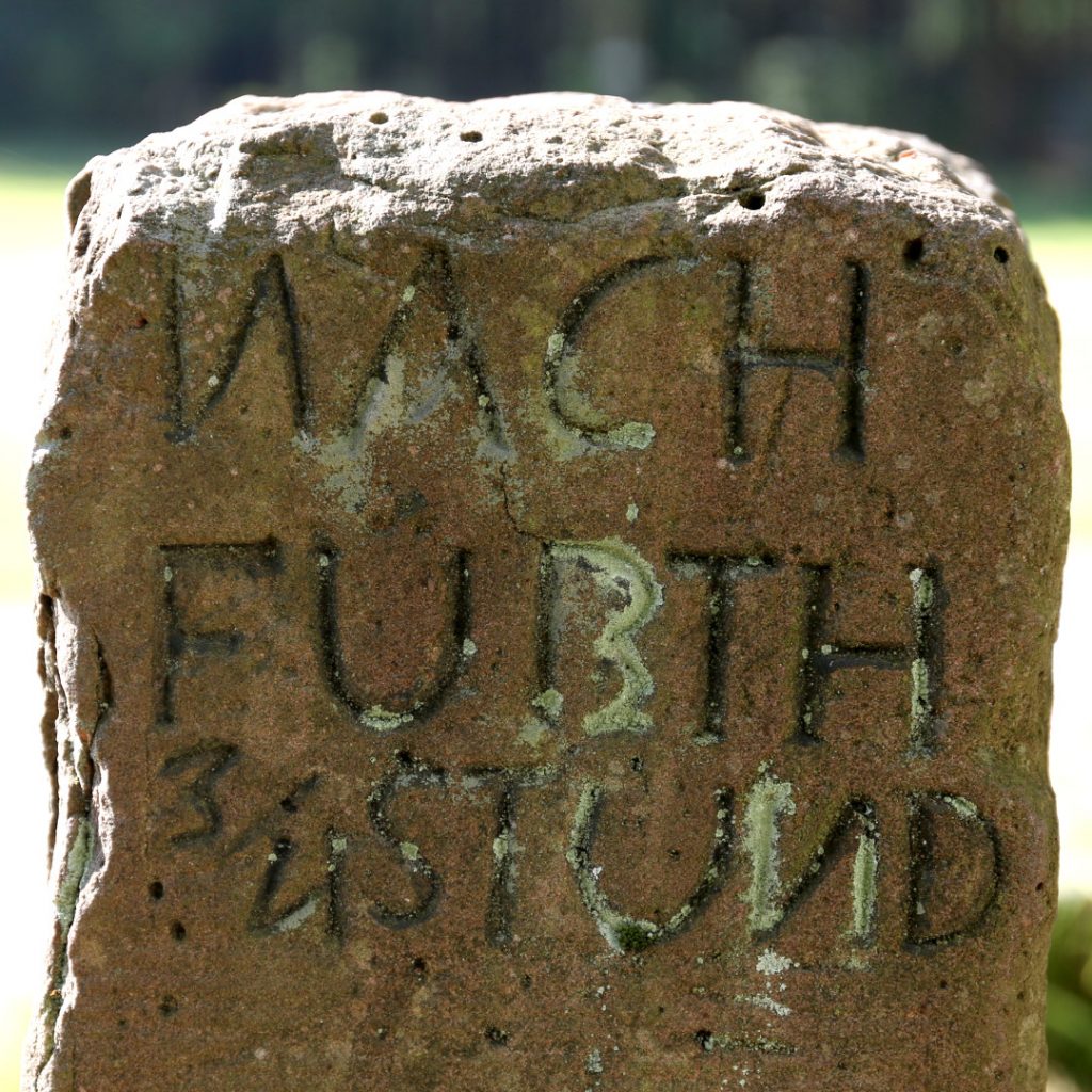 Ausschnitt aus einer alten Wegmarkierung aus Sandstein mit der Aufschrift: Nach Furth