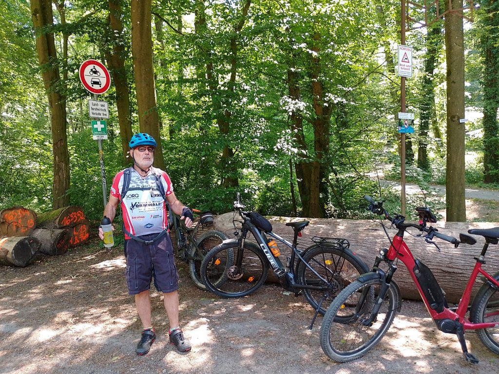 Mountainbiker steht bei Fahrrädern im Wald