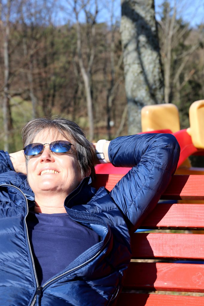 Frau sonnt sich auf Holzliege im Februar